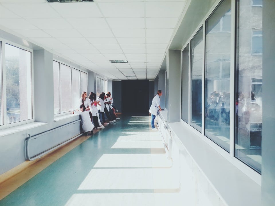 Doctors in a hospital hallway looking out the window
